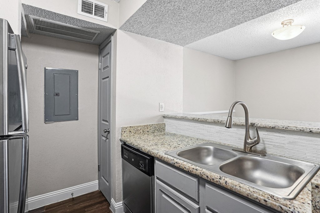 B1 kitchen with a granite countertop and stainless-steel appliances at Vine Apartments in Arlington, TX