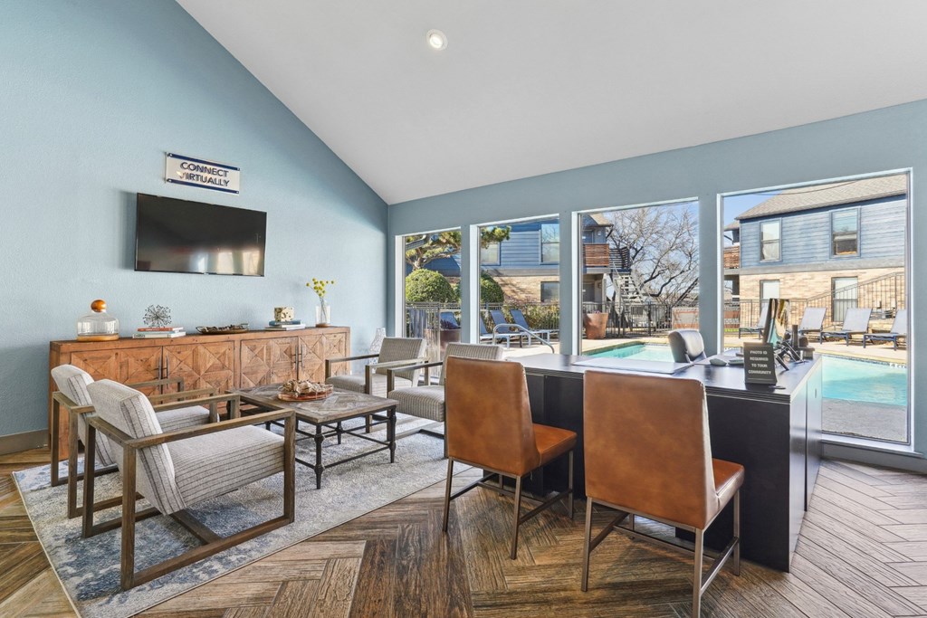 A leasing office with chairs and a large window at Vine Apartments in Arlington, TX