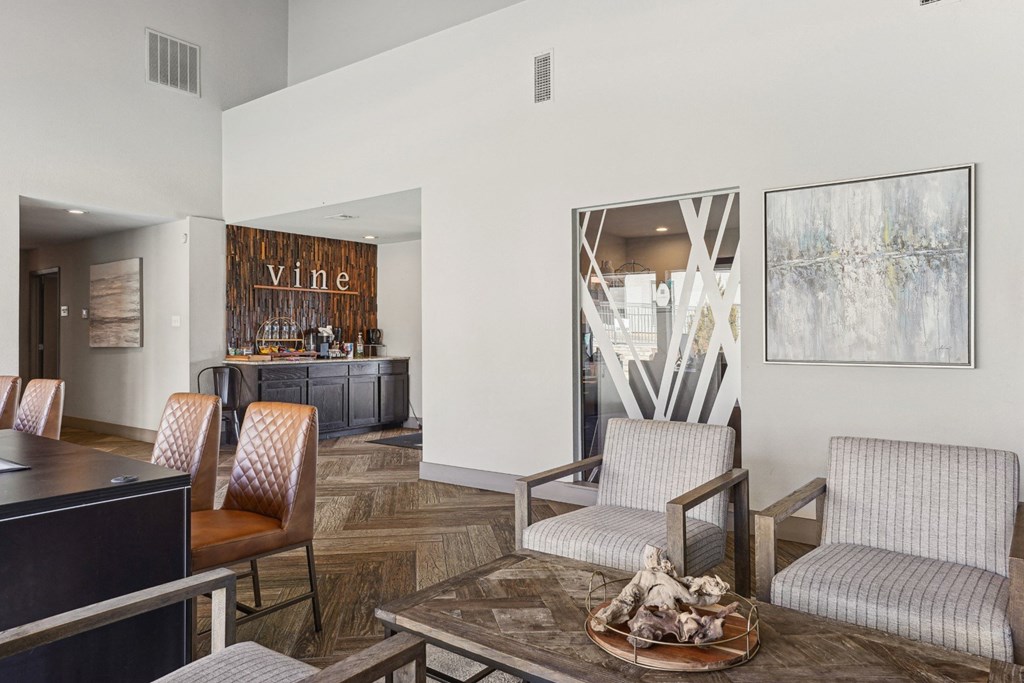 A modern leasing office with a wooden floor and a table at Vine Apartments in Arlington, TX