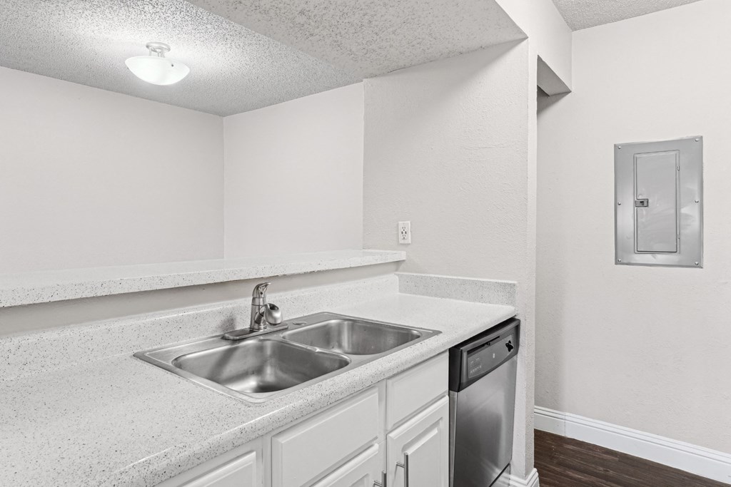 Upgraded A1 kitchen with a sink and a dishwasher at Vine Apartments in Arlington, TX