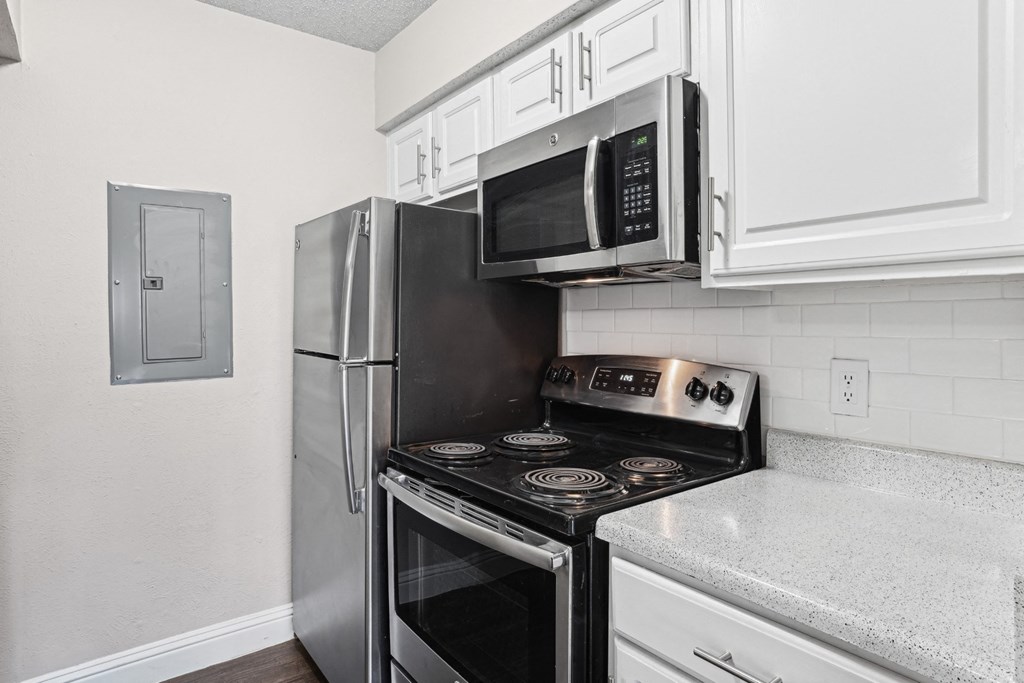 Upgraded A1 kitchen with a black stove top oven and a black refrigerator at Vine Apartments in Arlington, TX