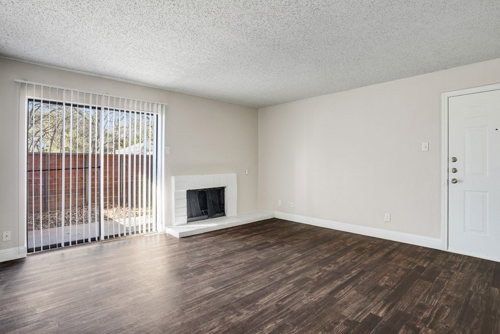 Upgraded A1 living room with a fireplace and wooden floors at Vine Apartments in Arlington, TX