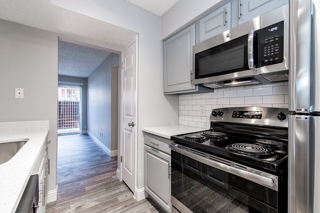 A2 upgraded apartment kitchen with a stove, microwave, and oven at Vine Apartments in Arlington, TX