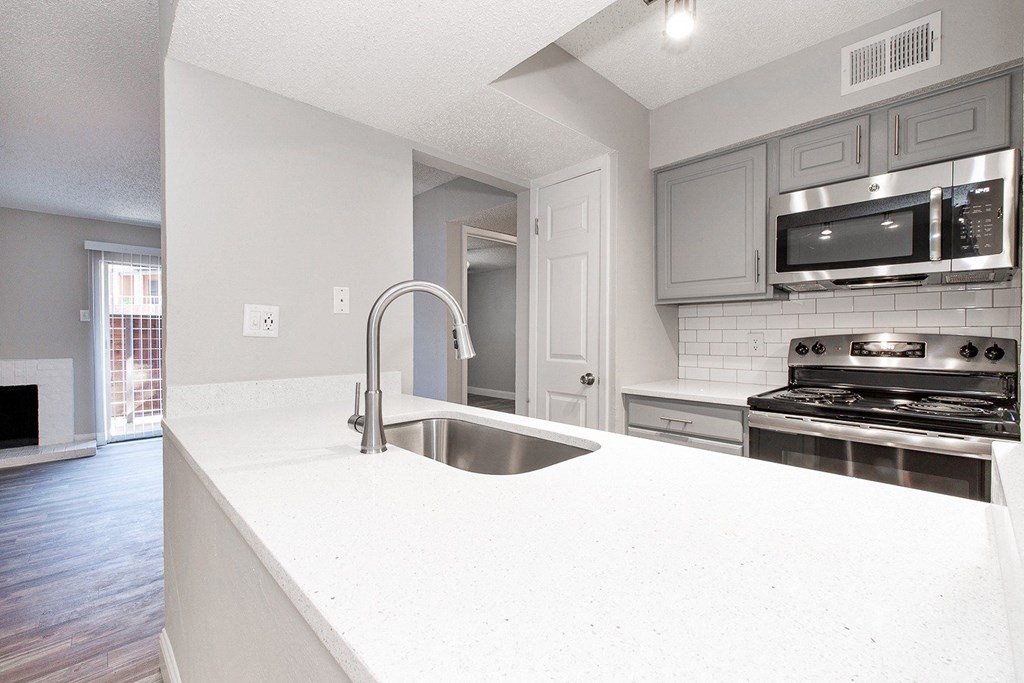 A2 upgraded apartment kitchen with a white counter top and stainless steel appliances at Vine Apartments in Arlington, TX