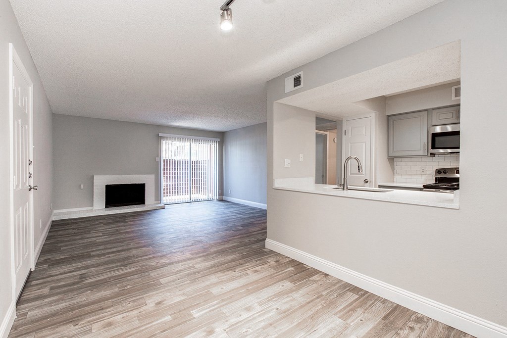 A2 upgraded apartment spacious living room with a fireplace and a kitchen at Vine Apartments in Arlington, TX