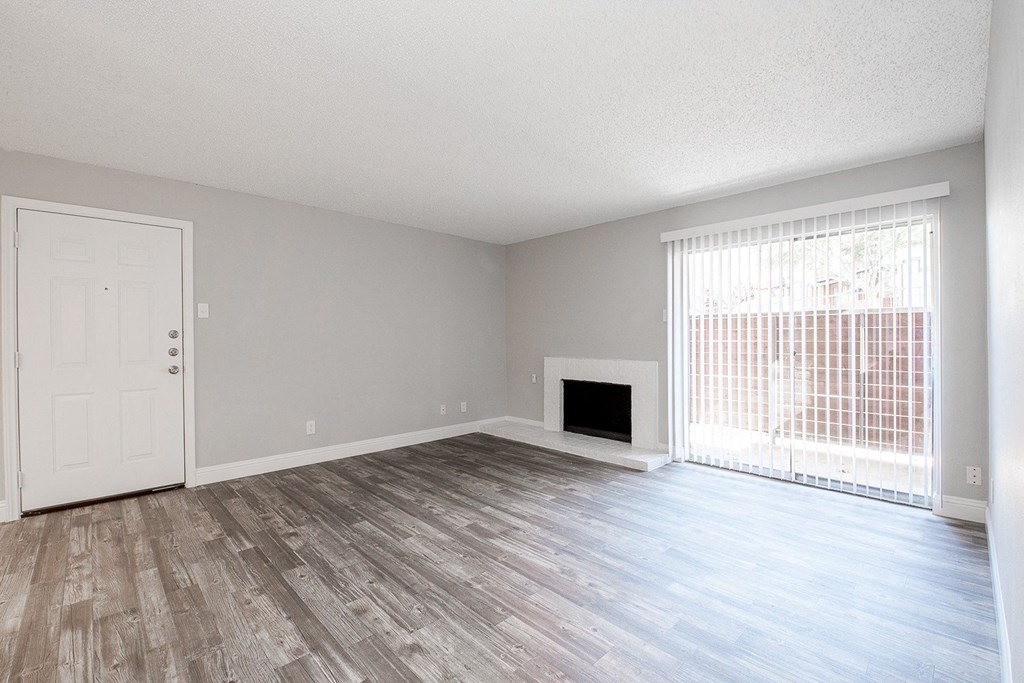 A2 living room with a fireplace and sliding glass door leading to patio at Vine Apartments in Arlington, TX