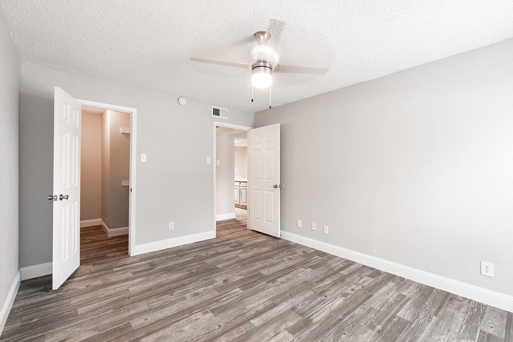 A2 upgraded apartment bedroom with ceiling fan and walk-in closet at Vine Apartments in Arlington, TX
