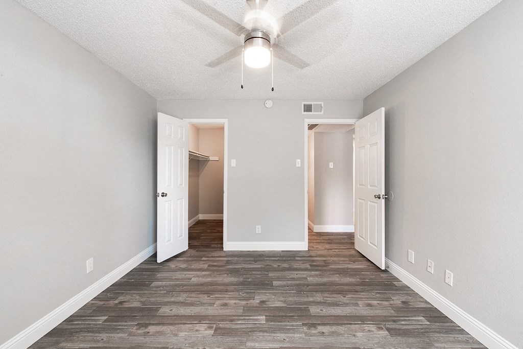 A2 upgraded apartment bedroom with doorways to entrance and walk-in closet at Vine Apartments in Arlington, TX