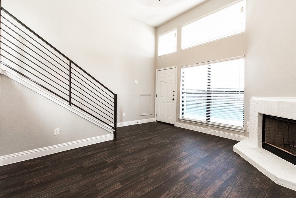 A4 entrance and living room with a fireplace and a staircase at Vine Apartments in Arlington, TX
