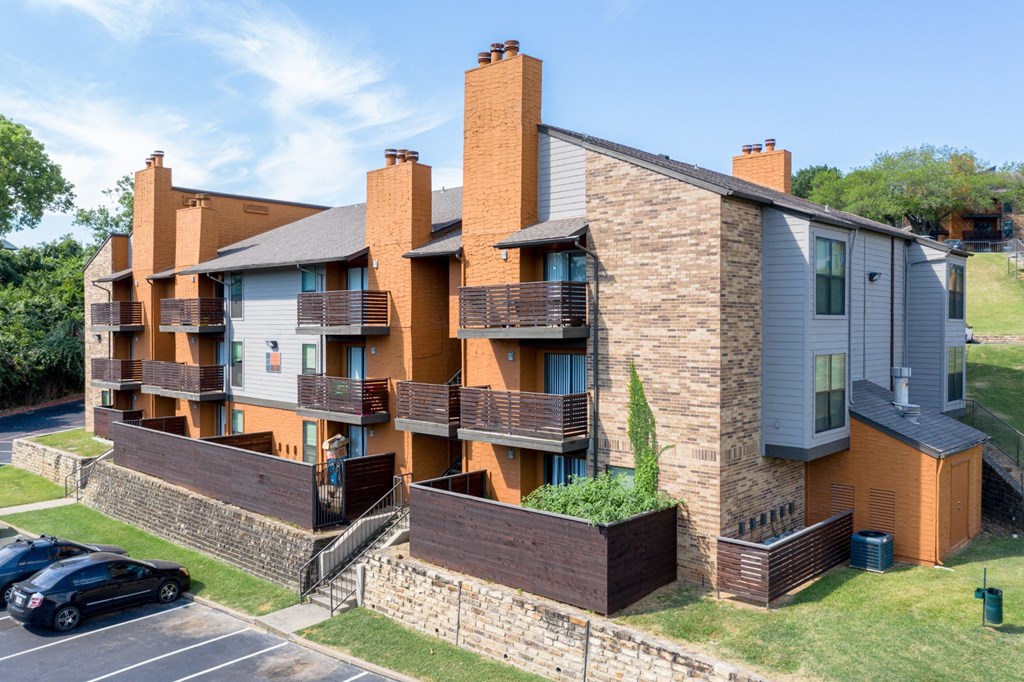 A modern apartment building with a parking lot in front at Vine Apartments in Arlington, TX