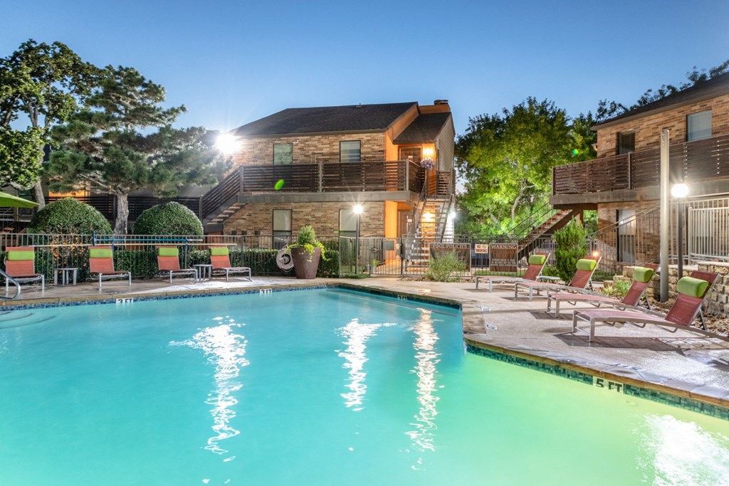 Swimming pool in front of apartments at dusk at Vine Apartments in Arlington, TX