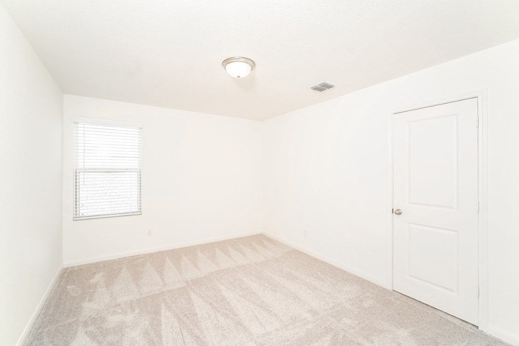 a bedroom with white walls and a white door