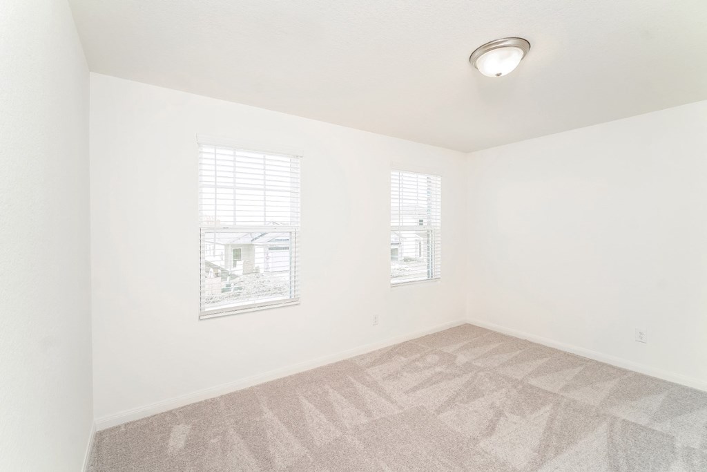 a bedroom with white walls and a carpeted floor