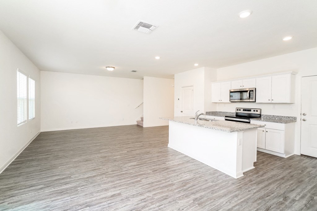 a kitchen and living room with white walls and wood flooring at Beacon at Meridian, Texas, 78245