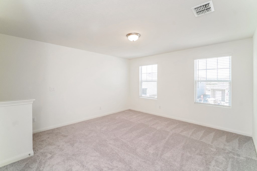 a bedroom with white walls and carpet