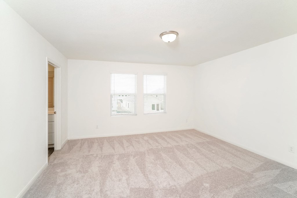 a bedroom with white walls and a carpeted floor