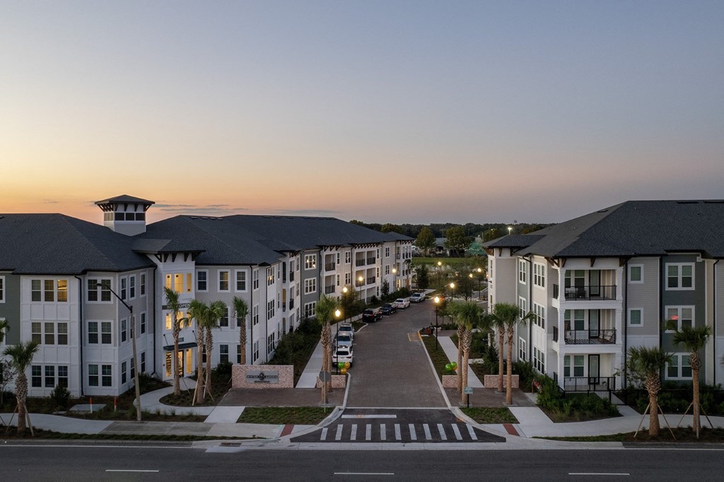 An aerial view of Vida Winter Garden Apartment on a city street at sunset