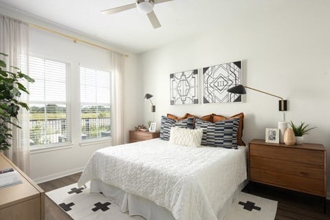A bedroom with a white bed and a ceiling fan at Vida Winter Garden in Winter Garden, FL