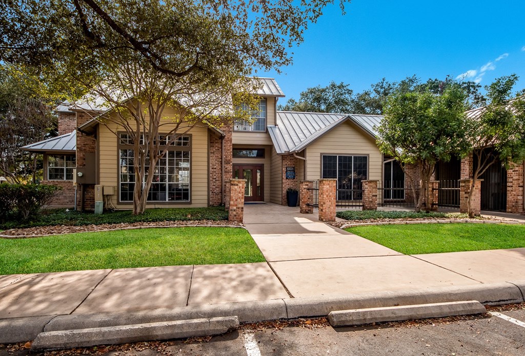 the front of a house with a sidewalk and grass
