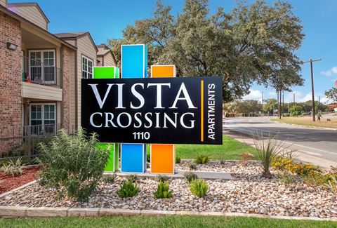 the sign at the entrance of the vista crossing apartments