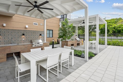 a patio with a white table and chairs and a grill at Westgate on Univeristy in Lauderhill, FL