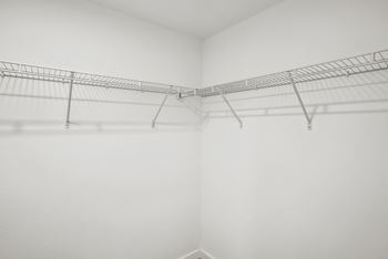 an empty walkin closet with white walls and a wire shelf on the wall at Westgate on University in Lauderhill, FL