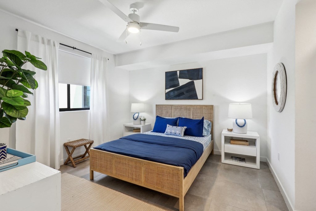 Bedroom in A1 Floor Plan with blue sheets and 2 nightstands at Westgate on University in Lauderhill, FL