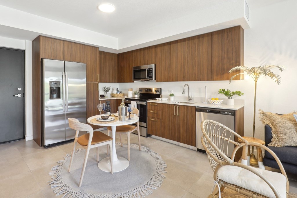 Kitchen in A1 Floor Plan with stainless steel appliances and a dining table at Westgate on University in Lauderhill, FL