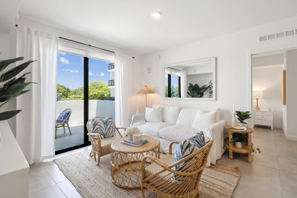 Living Room in B1 Floor Plan with white couch and sliding door to balcony at Westgate on University in Lauderhill, FL