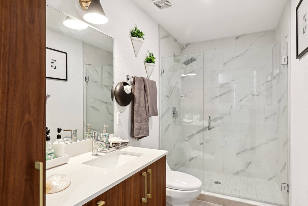Bathroom in A2 Floor Plan with walk-in shower and wooden cabinets at Westgate on University in Lauderhill, FL