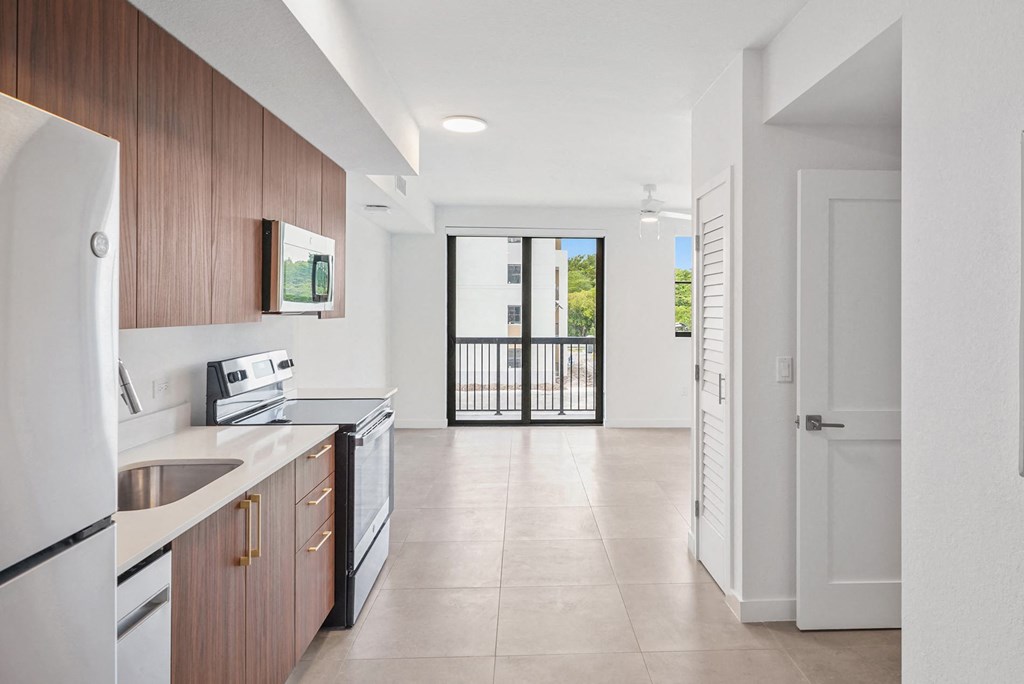 a kitchen with wooden cabinets and a white tiled floor