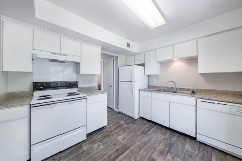 A kitchen with white appliances and cabinets.