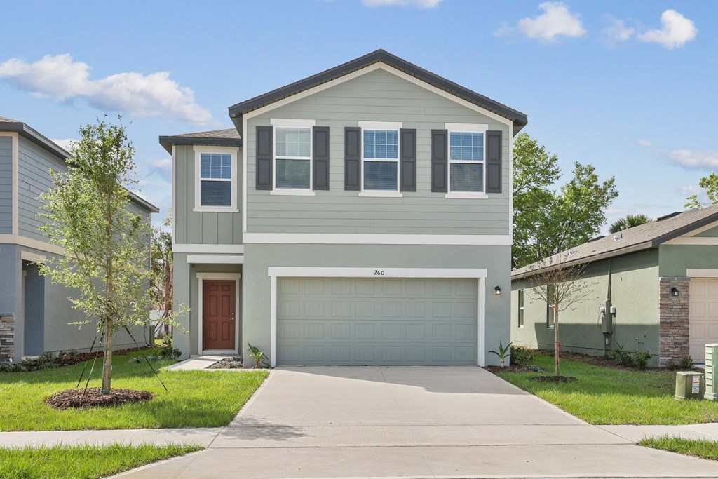 a home with a gray exterior and a brown garage door at Beacon at Woodland Village, DeLand Florida