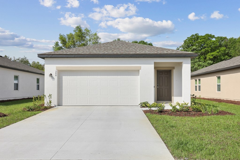 a home with a white garage door at Beacon at Woodland Village, DeLand, FL 32724