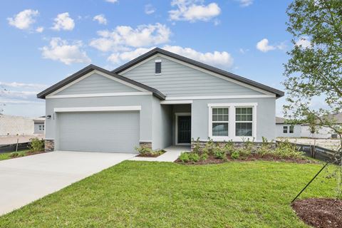 a home with a gray siding and a gray garage door at Beacon at Woodland Village, DeLand, FL 32724