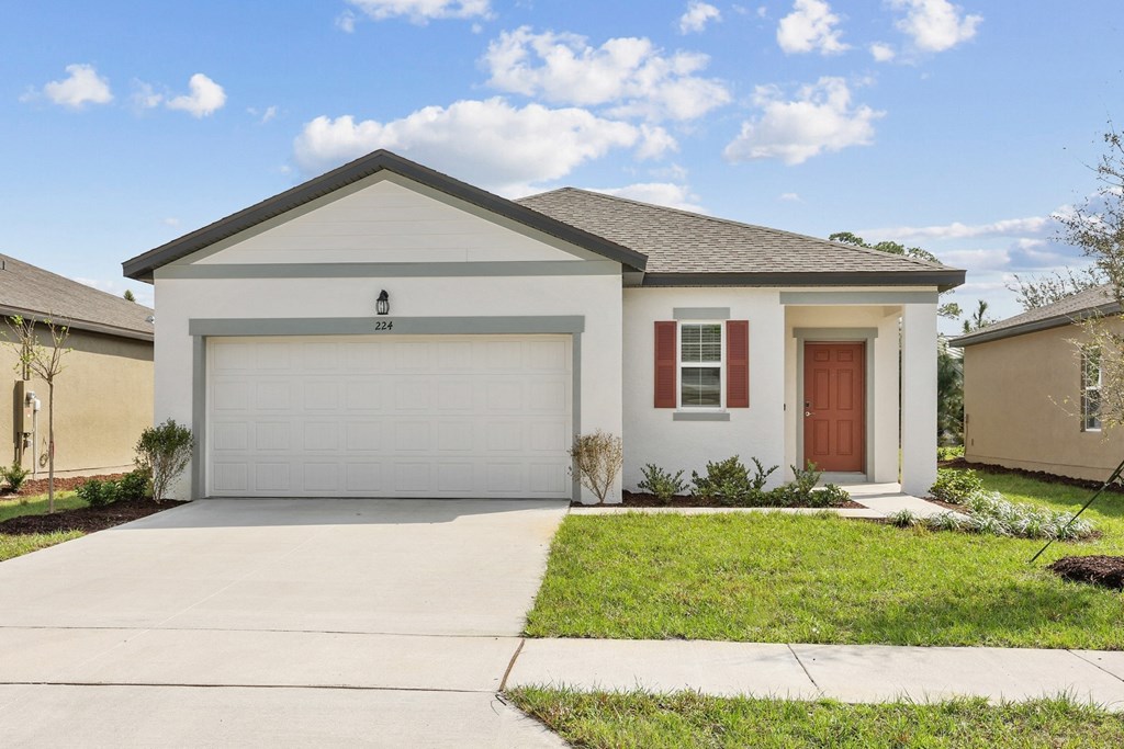 a home with a white house and a brown door at Beacon at Woodland Village, Florida, 32724