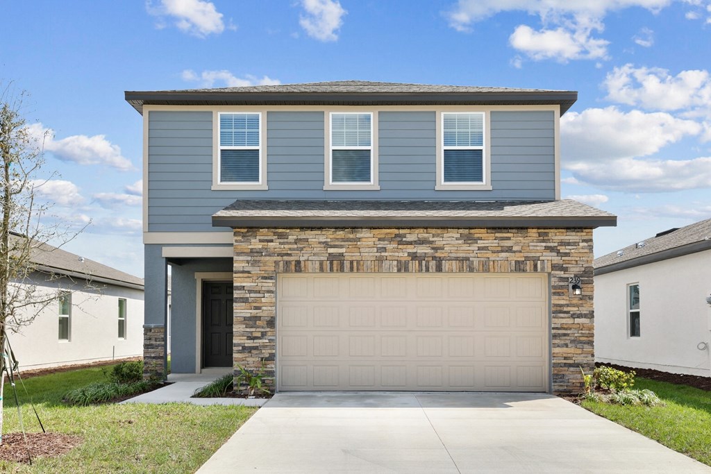 a house with a garage door in front of it at Beacon at Woodland Village, DeLand, FL