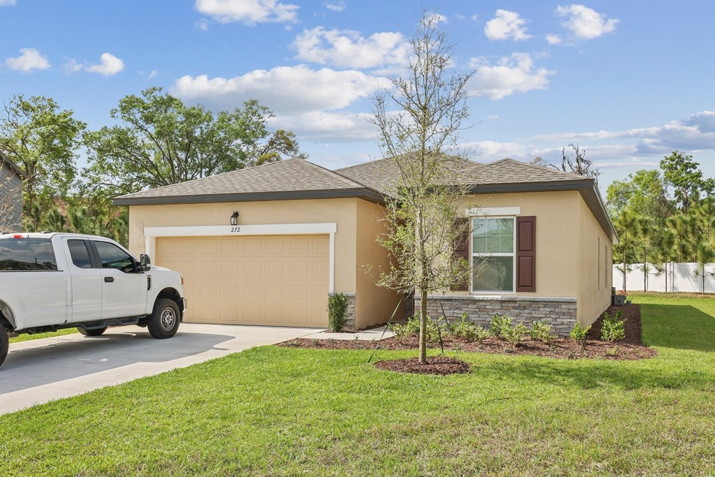 a home with a truck parked in the driveway at Beacon at Woodland Village, DeLand Florida