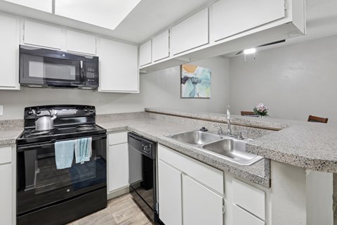 B1 kitchen with white cabinets and black appliances at Westdale Pointe in Austin, TX