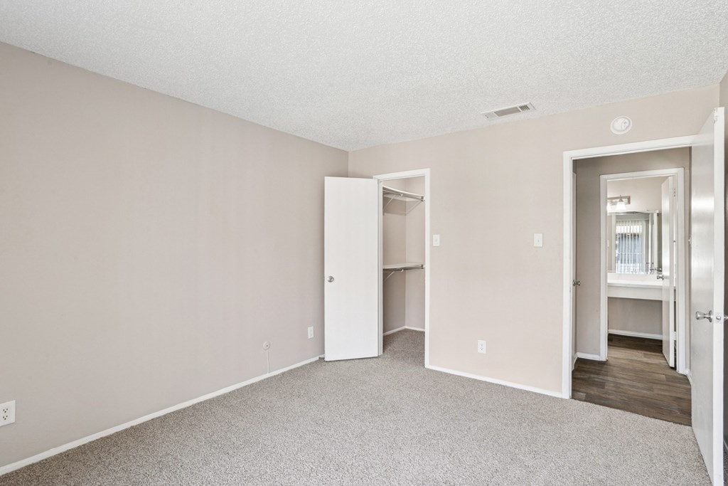 A5 bedroom looking toward the entrance and walk-in closet at Windridge on the Parkway apartments in Dallas, TX