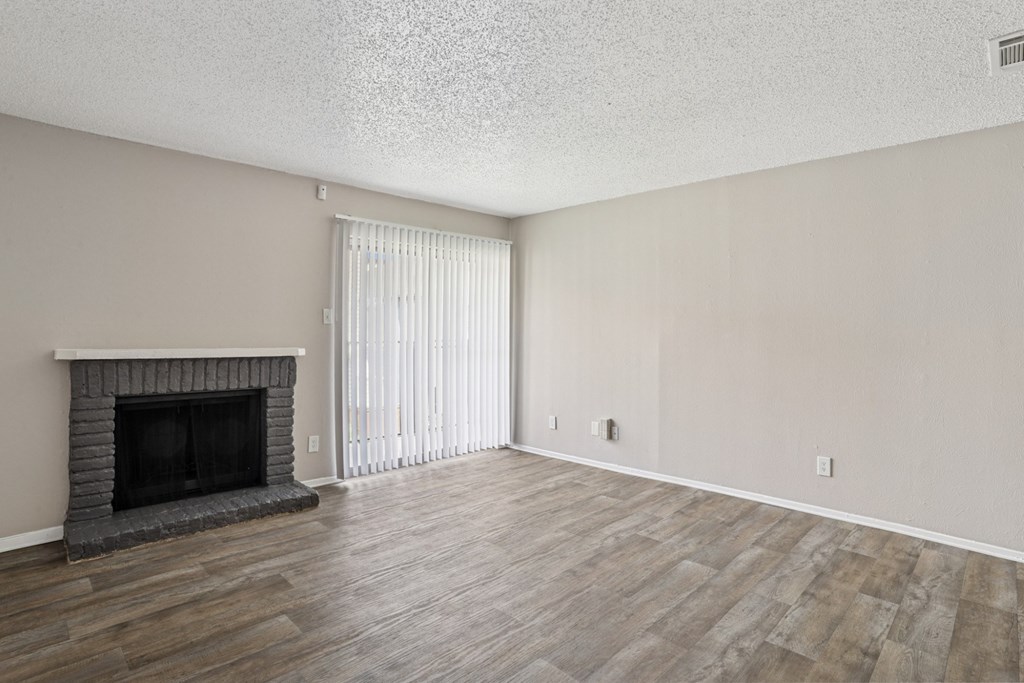 A5 living room with a fireplace and vinyl wood flooring at Windridge on the Parkway apartments in Dallas, TX