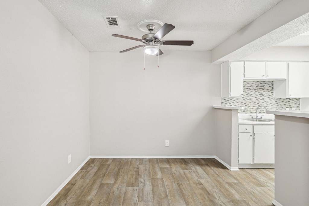 A6 dining room with a ceiling fan and vinyl wood flooring Windridge on the Parkway apartments in Dallas, TX.