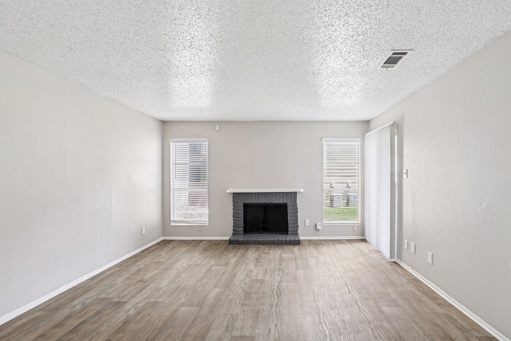 A6 living room with a fireplace and vinyl wood flooring Windridge on the Parkway apartments in Dallas, TX.