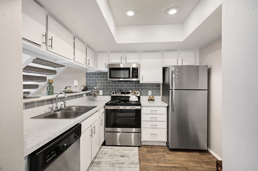 a kitchen with white cabinets and stainless steel appliances