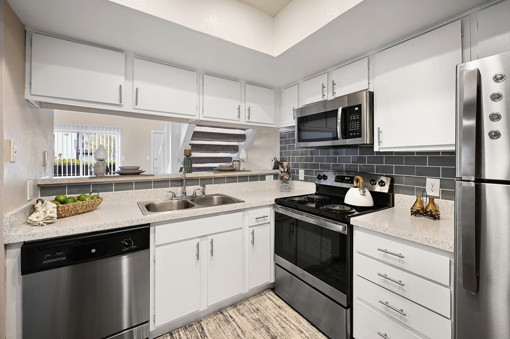 a kitchen with white cabinets and stainless steel appliances