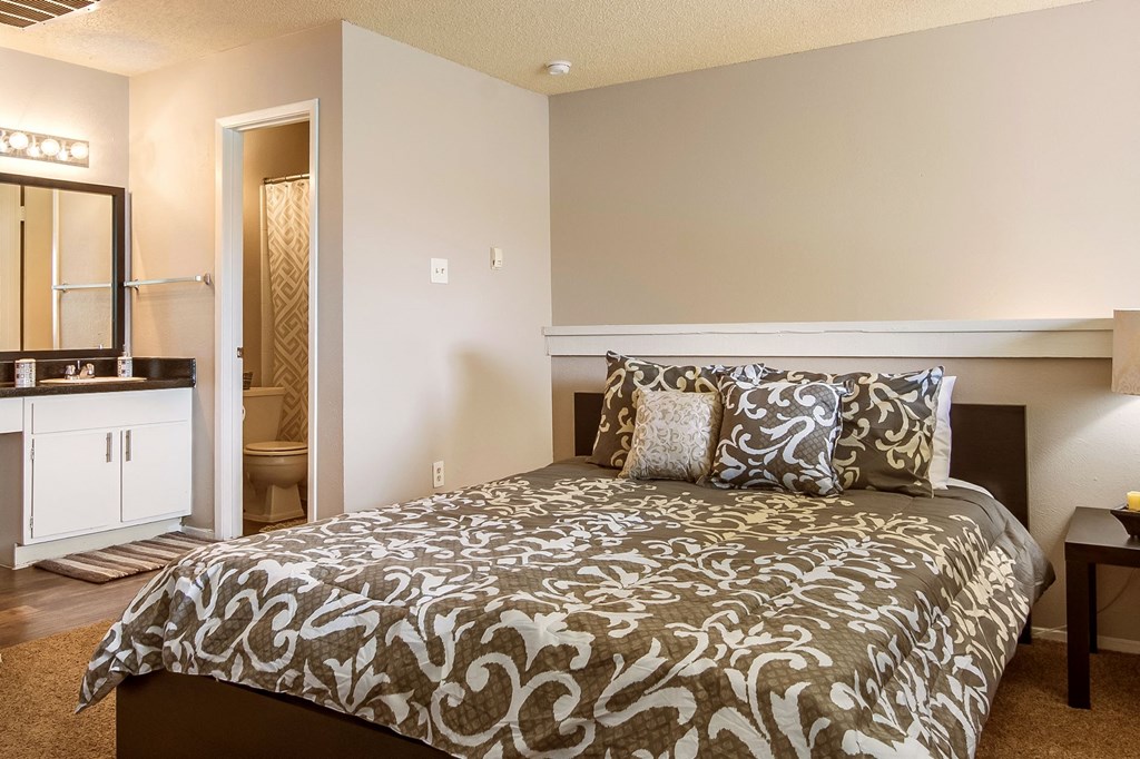 a bedroom with a bed and a bathroom with a sink