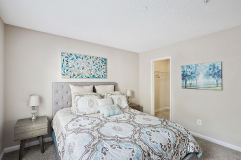 Model bedroom with a bed and two paintings on the walls at Wellington Ridge in Lawrenceville, GA