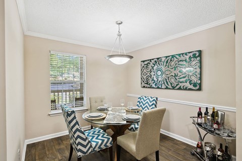 a dining room with a table and chairs and a window