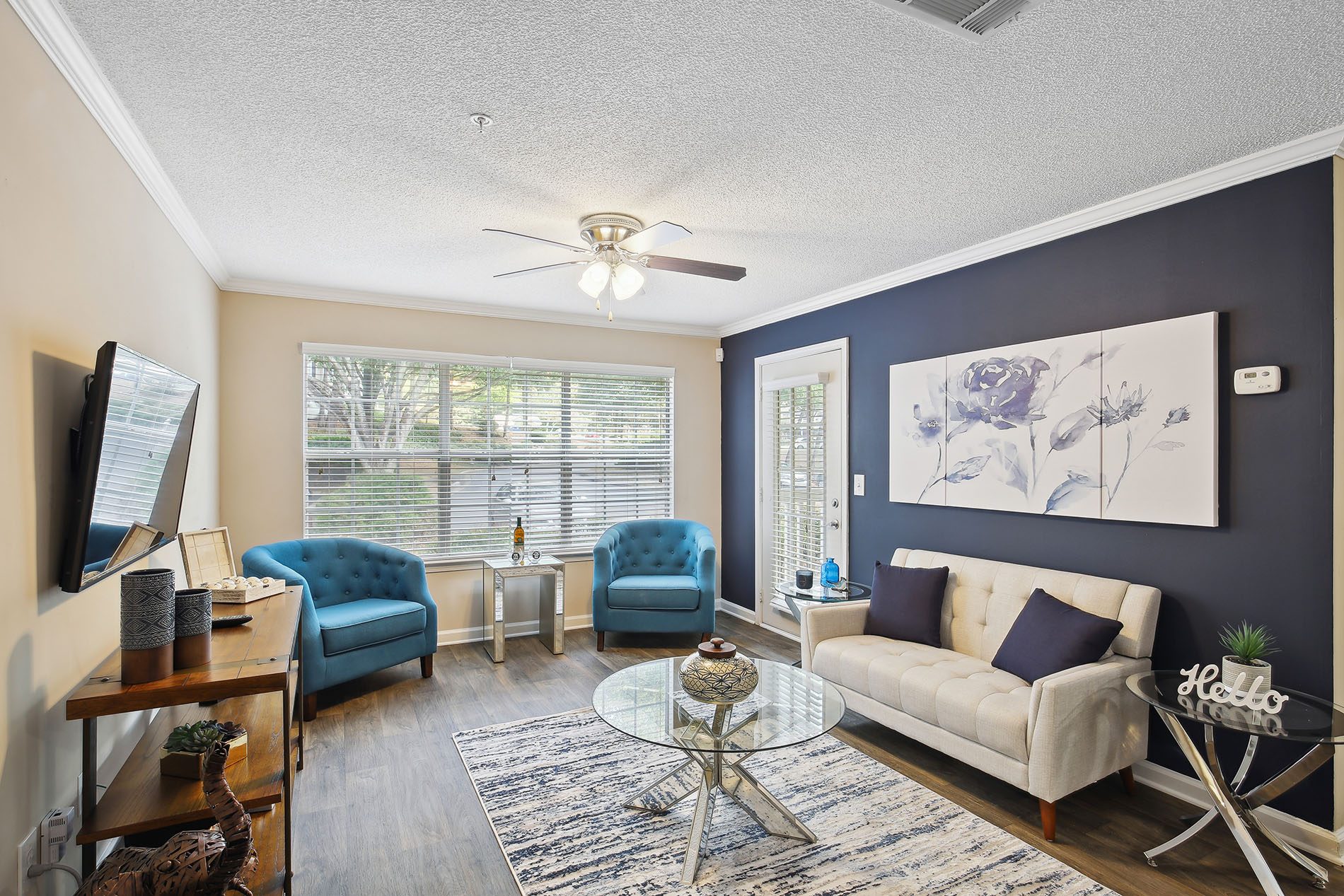 a living room with blue and white furniture and a ceiling fan