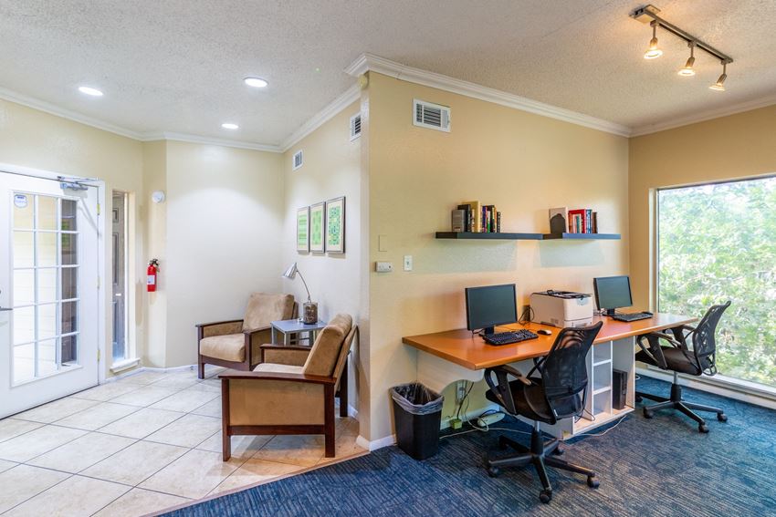 a home office with two computer desks and a chair